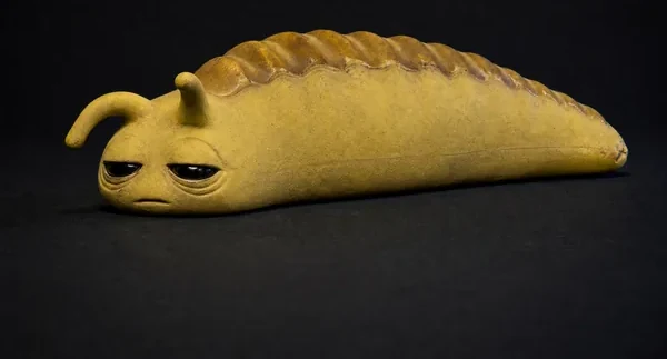 SLUG, a sulfur silicone creature, photographed as a specimen on a dark ground.